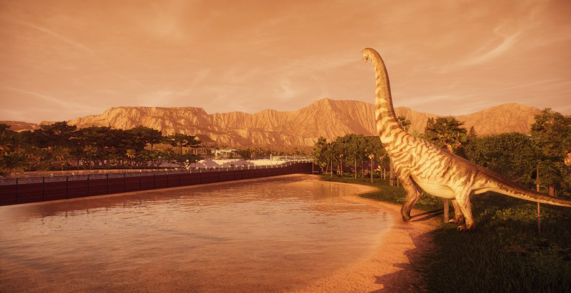 A sauropod strides towards a small lake, stretching high above the mountains on the horizon, sepia in the sunrise.